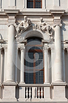 Window with statues on the top. Upper town of Bergamo, Italy