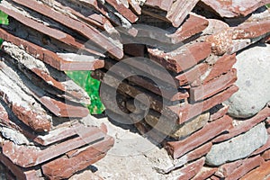 A window in a stone ornamental wall in a city park
