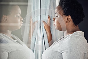 Window, thinking or black woman with depression, stress or mental health crisis by curtain at home. Worry, lonely lady