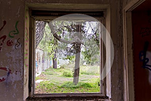 Window view of an abandoned old villa at Pallini, Greece