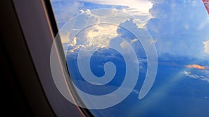 Window View on Airplane, Wing of Airplane With Sunlight on Sky, Cloudy Background,