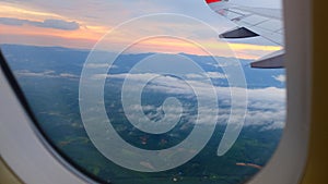 Window View on Airplane, Wing of Airplane With Sunlight on Sky, Cloudy Background,