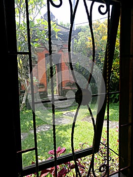 Window view of Balinese garden and side gate