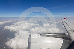 Window view from on commercial airplane with wing on clouds and beautiful sky of an aircraft, concept of travel and air