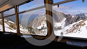 Window view of a Moving Mountain Train on the Snowy Switzerland Alps. Montreux City.