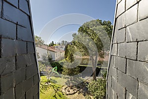 A window with views in a cottage with quirky roofs with black slate tiles