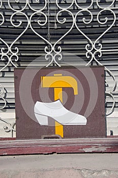 Window with vintage shoe repair shop sign