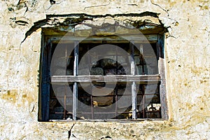 Window in the wall of an abandoned house. Old house. The ruins of the house. Window with bars