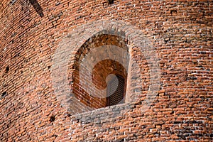 Window in the wall of an old red brick