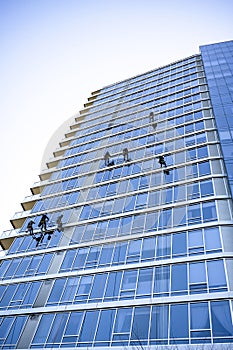 Window washers wash windows of high-rise buildings as the climbers descended and climbing on fixed ropes
