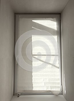 A window with a white curtain is open