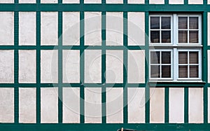 Window on a white wall with old wooden beams.