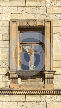 A window in a wide stone frame on a stone wall