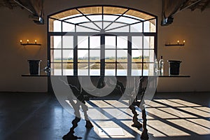 Window in Wine Cellar Bordeaux with view to vineyards.. Shadow of window on floor.