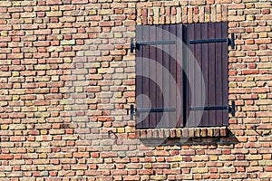 Window with wooden shutters on old brickwork in Brugge, Flanders, Belgium