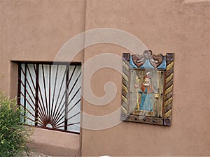 Window with wrought iron design and religious carving, Chimayo, New Mexico