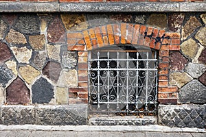 Window with wrought iron grille in the old house