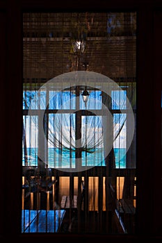 Through the window you can see the cafe`s atmosphere and the blue and turquoise sea and sky