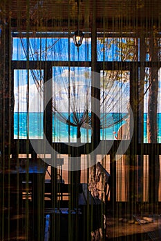 Through the window you can see the cafe`s atmosphere and the blue and turquoise sea and sky