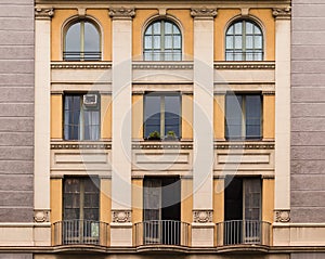 Windows and balconies in row on facade of historic building