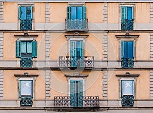 Windows and balconies in row on facade of historic building