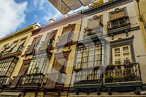 Windows, balconies and sunshades in a street in Seville, Spain