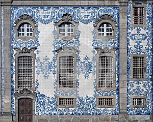 Windows and blue and white Azulejos patterns on the side facade of the Carmalitas Church in Porto, Portugal.