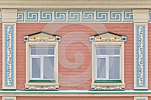 Windows with carved wooden architraves on facade of house of 19th century, Kazan, Russia