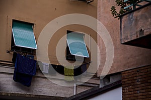 Windows closed by curtains and clothes hanging on a facade of a condominium