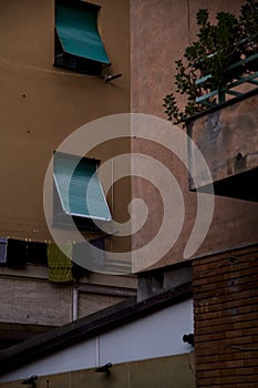 Windows closed by curtains and clothes hanging on a facade of a condominium