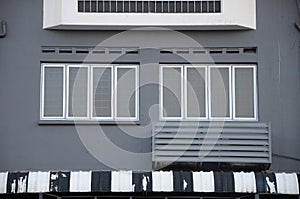 Windows on a dark grey wall with an air-conditioning radiator by the ledge