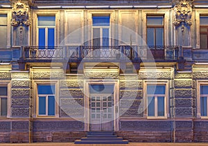 Windows, door and balcony on night facade of apartment building