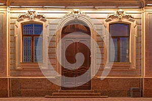 Windows and door on night facade of apartment building