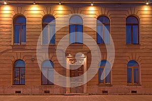 Windows and door on night facade of apartment building