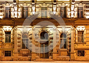 Windows and door on night facade of apartment building