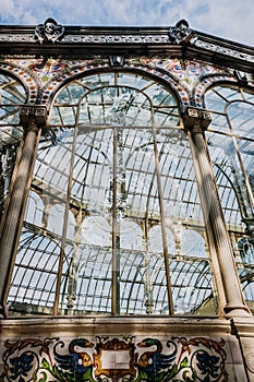 Windows of the glass palace of the Retiro Park in Madrid, with a background of a sky with clouds