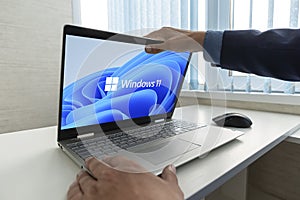 Windows 11 logo on laptop screen. A new operating system update from Microsoft