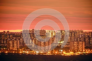 Windows of the night city building and roads with cars. Pink evening sunset over modern Moscow  Russia