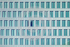 Windows pattern on cyan modern skyscraper or glazed office facade conveys concept of shared office space or corporate headquarter