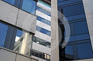 Reflections in the windows of a group of large modern office buildings in a city business district