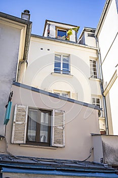 Windows of residential apartments in an old multi-story building overlooking the courtyard at Montmartre in Paris