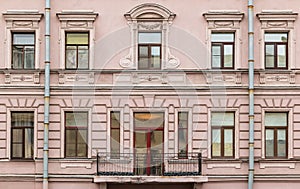 Windows in a row and balcony on facade of apartment building