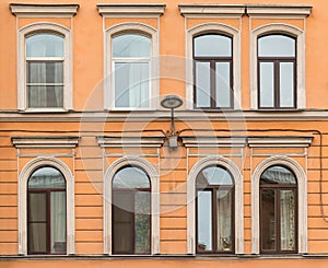 Windows in a row and streetlight on facade apartment building