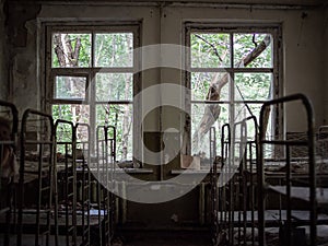 Windows and rusty beds in abandoned Kindergarten in Pripyat, Chernobyl