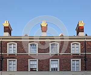 Windows and chimneys on a row of elegant brick 18th century english houses in chester
