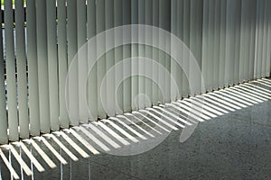 Windows with vertical blinds, Detail of the interior texture with lights and shadows on the floor