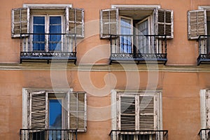 Windows with weathered wooden frames, blinds, and balconies. photo