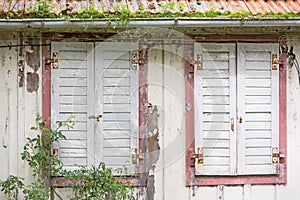 Windows with window shutters of an decayed house