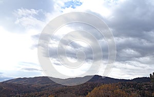 Winds of Change: Autumn Rainstorm Rising Over Mountain Ridge