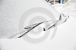 Windscreen wipers and a snow covered car.